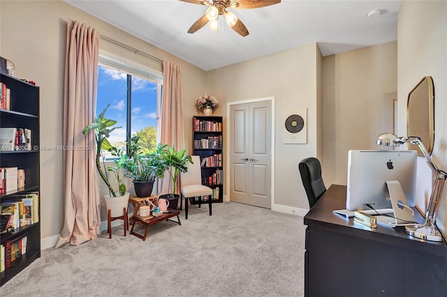 carpeted home office with baseboards and a ceiling fan