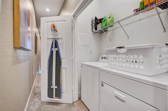 clothes washing area with laundry area, independent washer and dryer, baseboards, and a textured wall