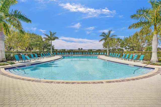 community pool featuring a patio area and fence