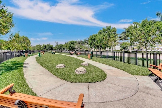 view of community featuring a yard and fence