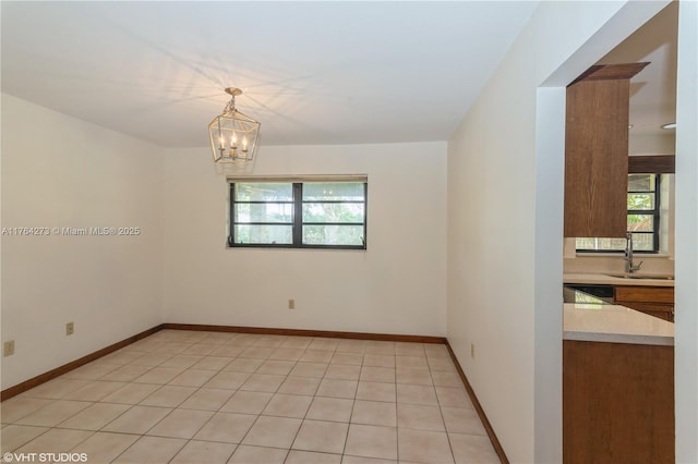 27820 SW 164th Ct, Homestead, FL 33031 - empty room with baseboards, a notable chandelier, a healthy amount of sunlight, and a sink