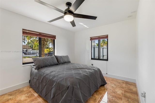 bedroom with multiple windows, baseboards, and ceiling fan