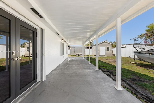 view of patio featuring a fenced backyard, an outdoor structure, and a shed