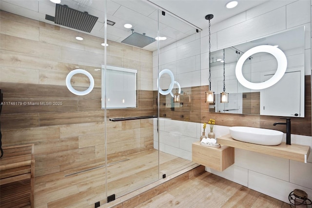 full bathroom with wood finished floors, a stall shower, and vanity