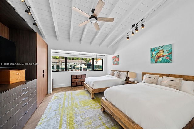 bedroom with light wood-type flooring, lofted ceiling with beams, rail lighting, baseboards, and wood ceiling