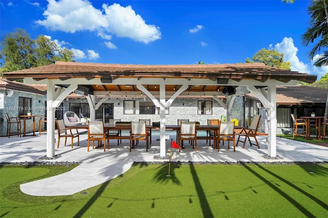 back of house with a gazebo, a patio area, and stone siding