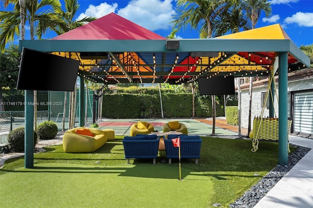 view of community featuring a carport, a lawn, and fence