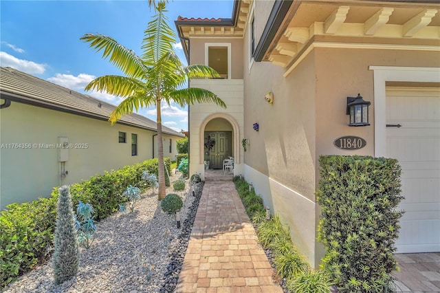 doorway to property with stucco siding and a garage