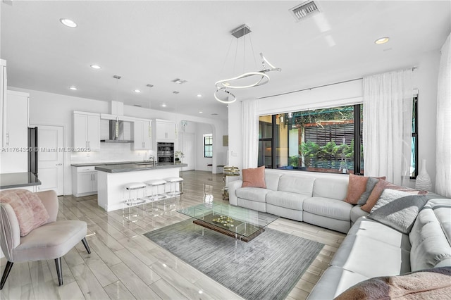 living room with recessed lighting, visible vents, and light wood-style floors