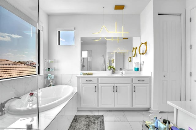 bathroom featuring a bath, marble finish floor, and vanity