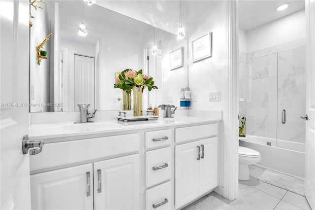 bathroom featuring double vanity, toilet, marble finish floor, and a sink