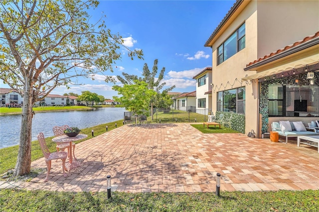 view of patio featuring a residential view, a water view, fence, and an outdoor hangout area