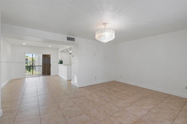 unfurnished room featuring light tile patterned floors, visible vents, baseboards, and an inviting chandelier