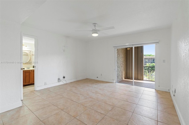 empty room featuring light tile patterned floors, baseboards, and ceiling fan