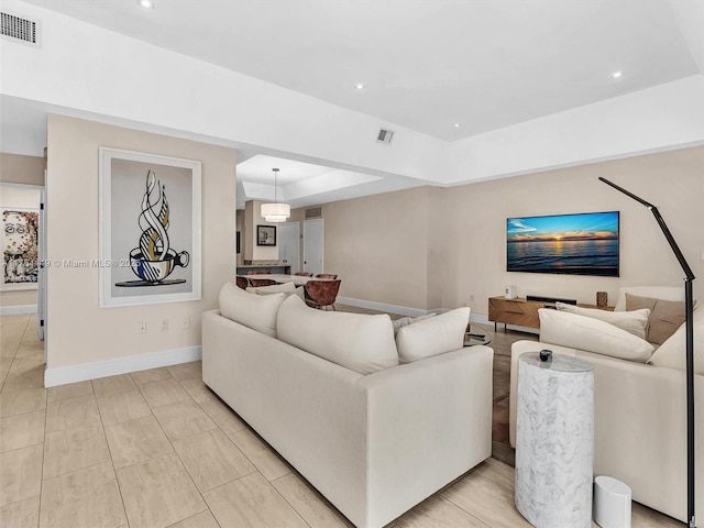 living room featuring recessed lighting, visible vents, and baseboards