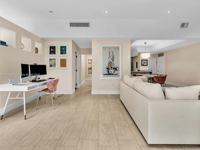 living area with recessed lighting, visible vents, and baseboards