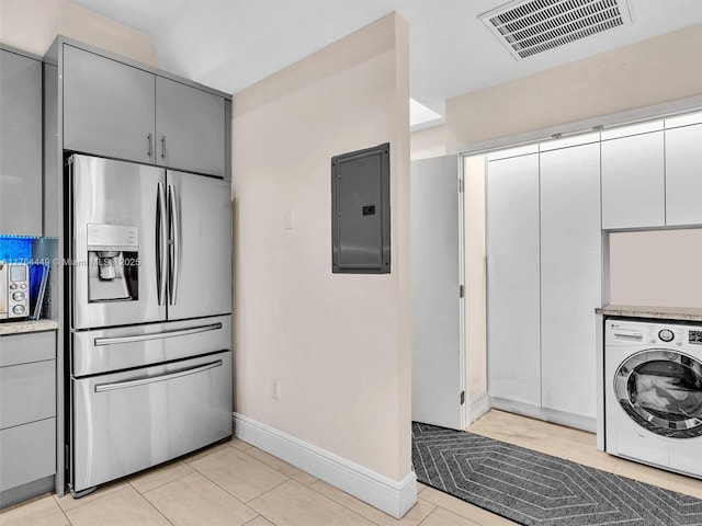 kitchen with visible vents, gray cabinetry, electric panel, washer / dryer, and stainless steel refrigerator with ice dispenser