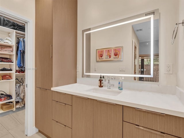 bathroom featuring vanity, tile patterned floors, a spacious closet, and visible vents