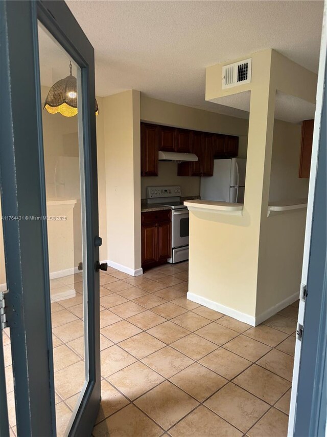 815 W Boynton Beach Blvd Unit 6-103, Boynton Beach, FL 33426 - kitchen with white appliances, under cabinet range hood, light tile patterned floors, and a textured ceiling