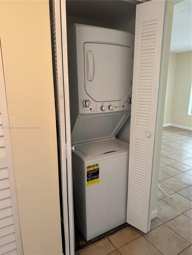 815 W Boynton Beach Blvd Unit 6-103, Boynton Beach, FL 33426 - laundry room with stacked washing machine and dryer and light tile patterned flooring