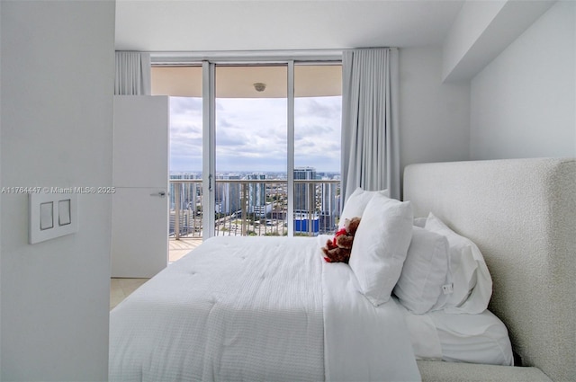 bedroom featuring a city view, access to outside, and multiple windows