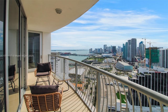 balcony featuring a water view and a city view