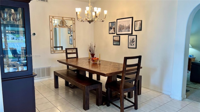 dining room with visible vents, baseboards, light tile patterned floors, arched walkways, and a notable chandelier