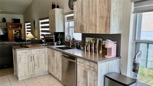 kitchen with light brown cabinets, a sink, dark countertops, a peninsula, and dishwasher