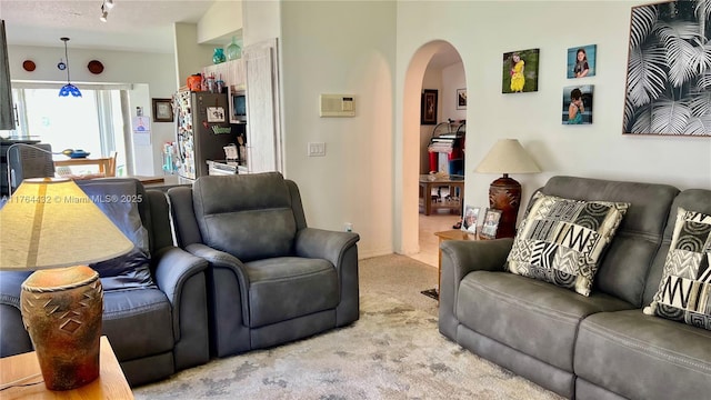 living room with arched walkways and carpet floors