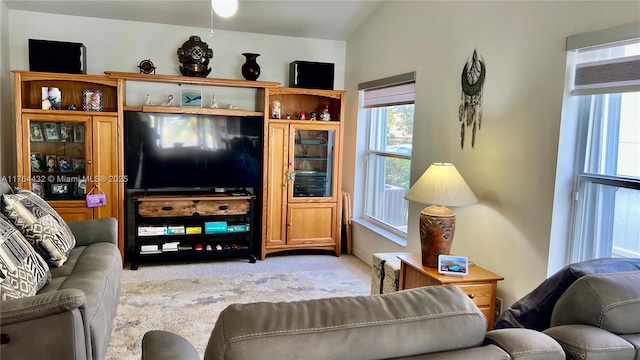 carpeted living area with lofted ceiling