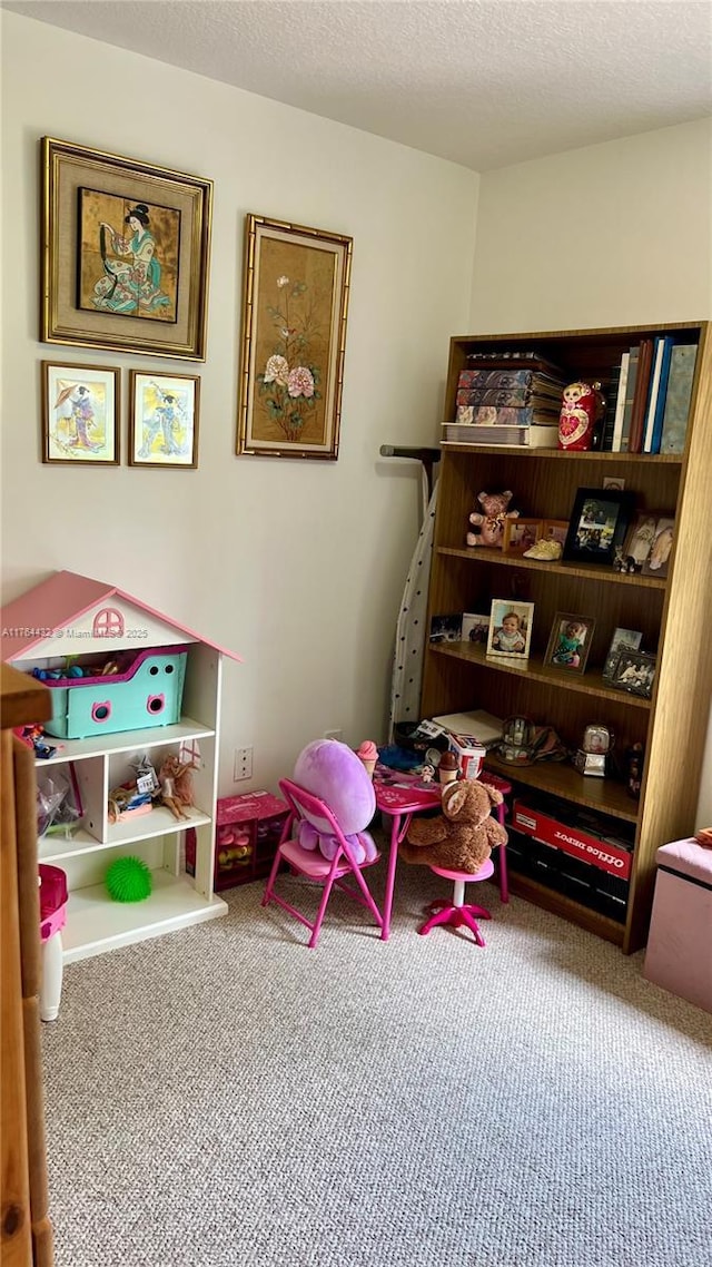 playroom featuring carpet and a textured ceiling