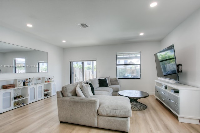 living room with recessed lighting, visible vents, and light wood finished floors