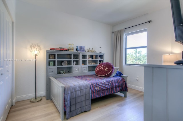 bedroom featuring baseboards and light wood finished floors