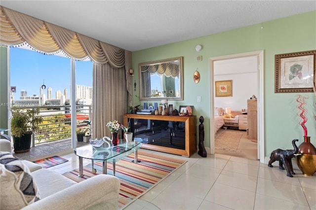 living area with light tile patterned floors, baseboards, plenty of natural light, and a view of city