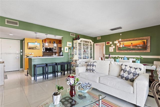 living room featuring light tile patterned flooring and visible vents