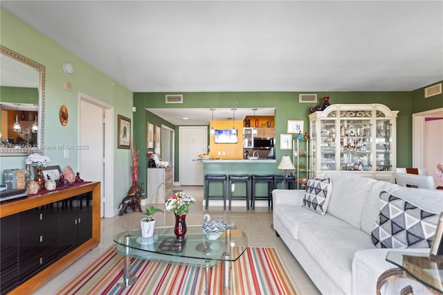 living area with tile patterned floors and visible vents