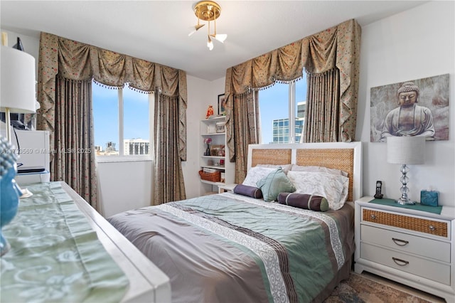 bedroom with multiple windows and a view of city