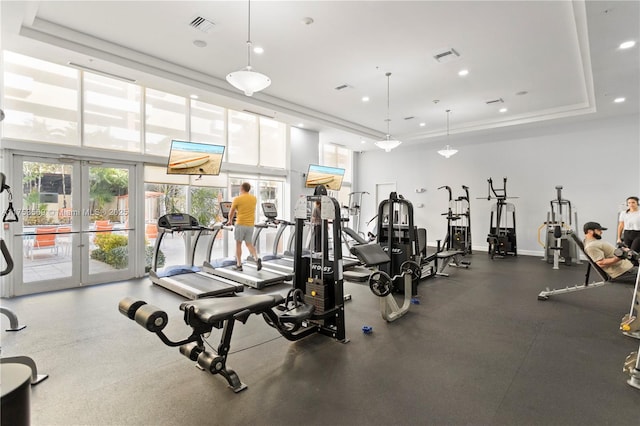 gym with a tray ceiling, french doors, visible vents, and recessed lighting