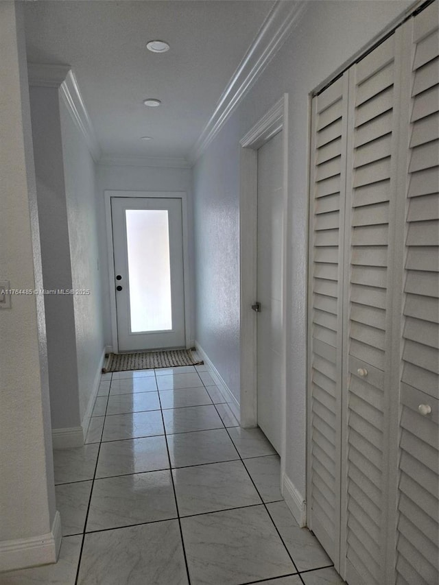 hall with crown molding, baseboards, and a textured wall