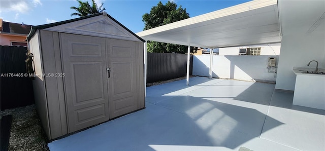 exterior space with a storage unit, an outdoor structure, a fenced backyard, and a carport