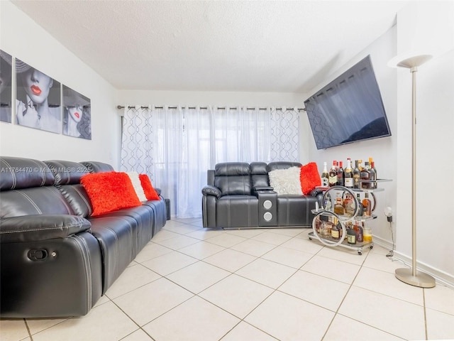 tiled living area featuring a textured ceiling and baseboards