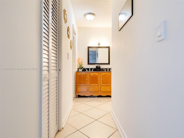 hall with light tile patterned floors and baseboards