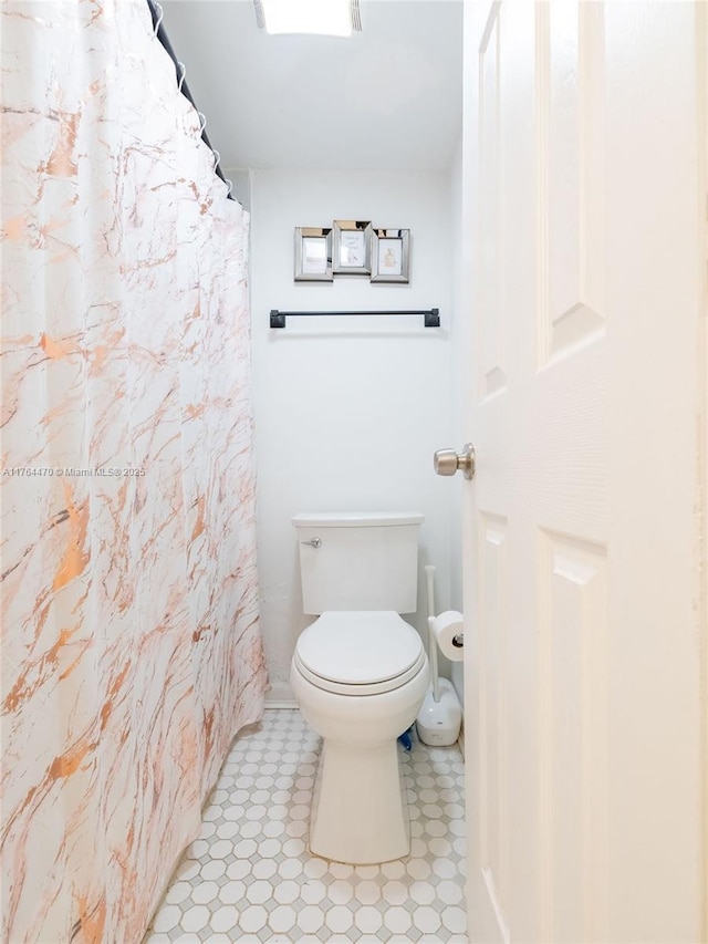 bathroom featuring a shower with curtain and toilet