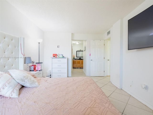 unfurnished bedroom featuring light tile patterned floors, visible vents, a textured ceiling, and baseboards