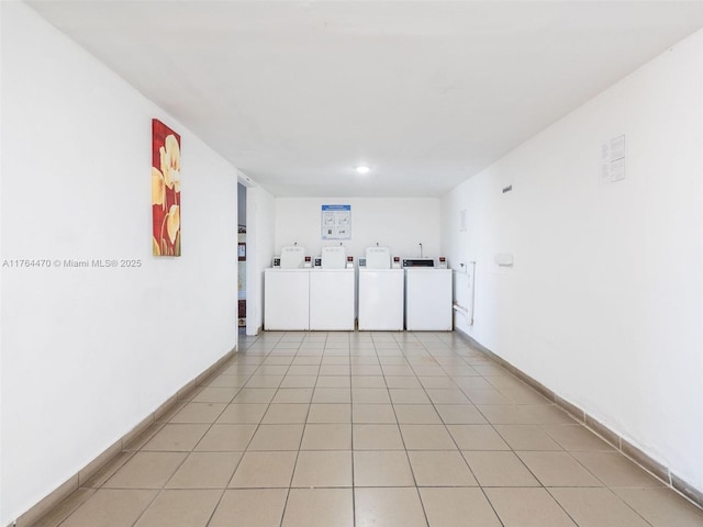 unfurnished room featuring washer and dryer, light tile patterned flooring, and baseboards