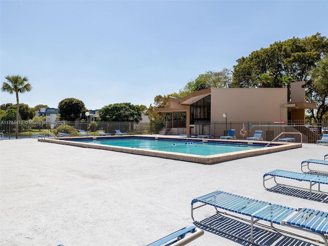 pool with a patio and fence