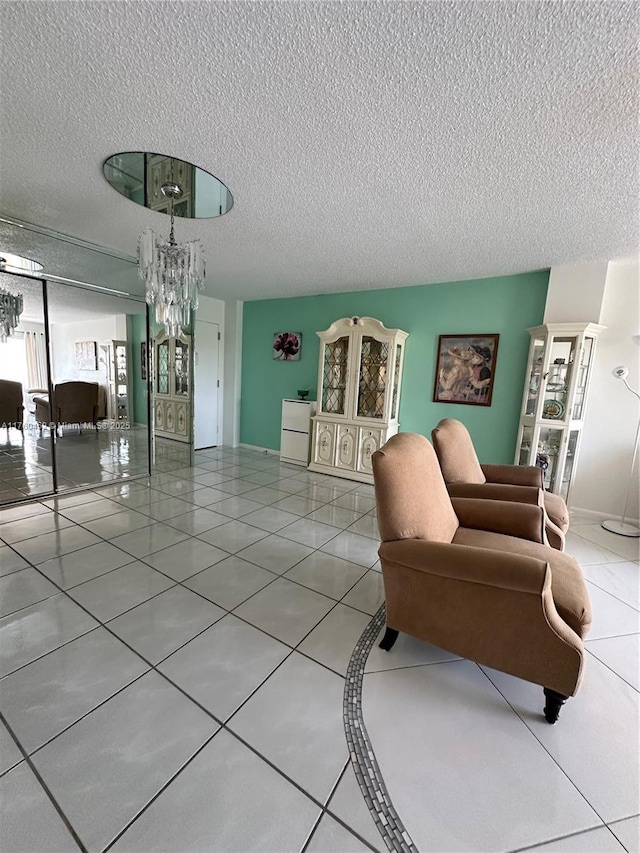 tiled living area with a notable chandelier and a textured ceiling