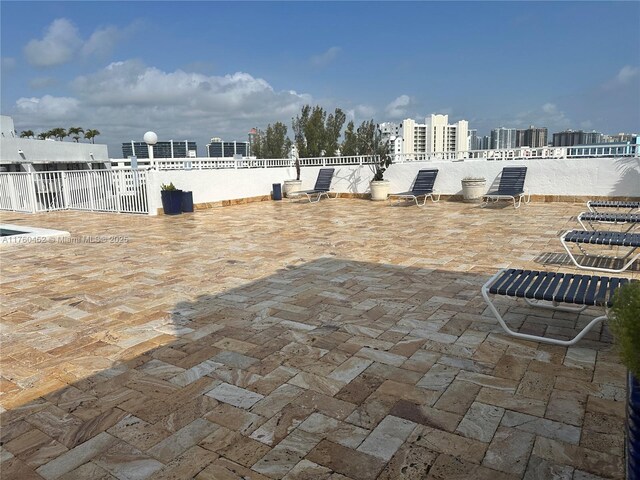 view of patio / terrace with a view of city and fence