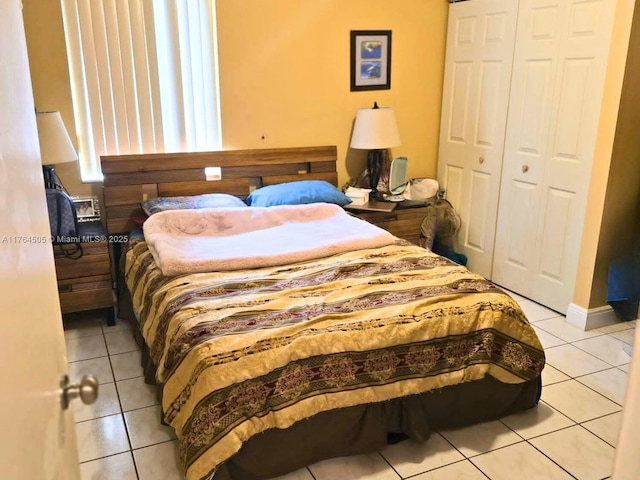 bedroom with light tile patterned floors and a closet