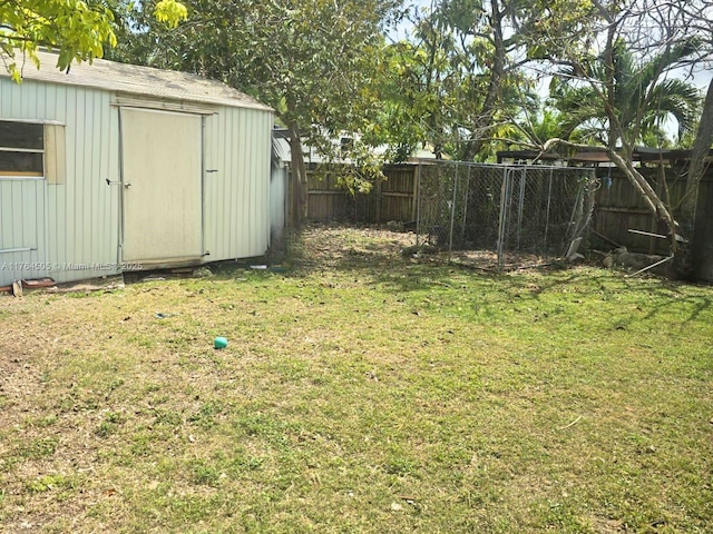 view of yard with an outbuilding, a fenced backyard, and a shed